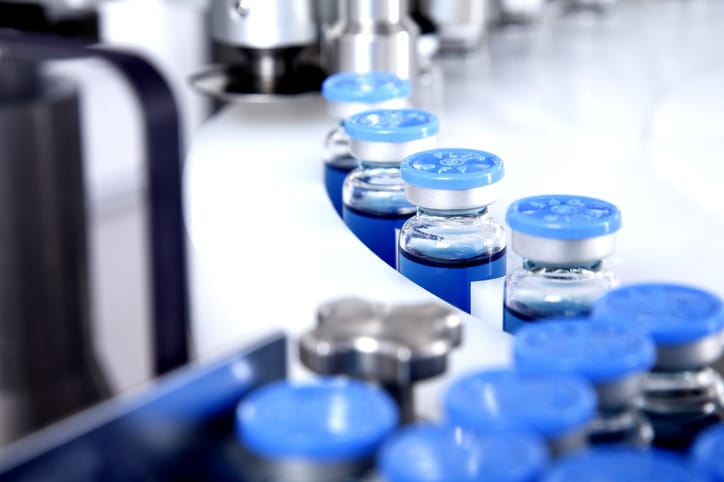 Glass bottles in production in the tray of an automatic liquid dispenser, a line for filling medicines against bacteria and viruses, antibiotics and vaccines