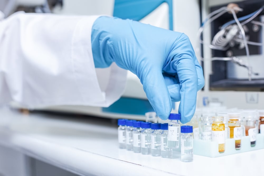 Scientist arranges vials of samples in order of sample or prepare samples for analysis.